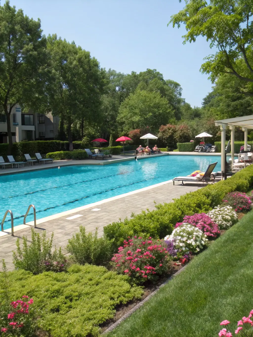 A vibrant photo of the main swimming pool at Rookery 3, showcasing families enjoying the water and the surrounding lounge chairs under sunny skies.